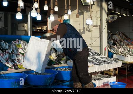 Istanbul, Turchia - 14 gennaio 2020: Un Fishmonger al suo stand nel mercato del pesce vicino al ponte di Galata chiamato Karakoy Balik Pasari Foto Stock