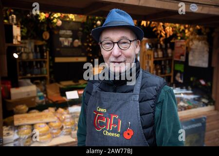 John Savage-Onstwedder di Caws Teifi, uno dei titolari del mercatino di Natale di Chester di quest'anno. Il mercato è stato votato come uno dei migliori 20 mercatini di Natale in Europa. Nel 2019, aveva circa 70 bancarelle gestite da rivenditori indipendenti. Foto Stock