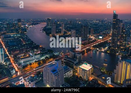 Veduta aerea dell'epico cielo del tramonto sopra il paesaggio urbano di Bangkok e il fiume Chao Phraya. Vista panoramica sulla notte della città asiatica con traffico intenso Foto Stock