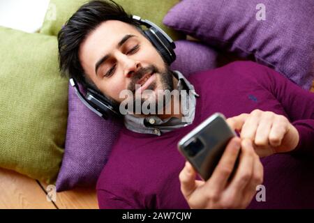 Uomo che indossa le cuffie per ascoltare musica Foto Stock