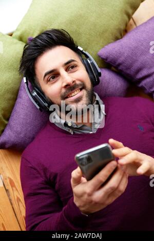 Uomo che indossa le cuffie per ascoltare musica Foto Stock