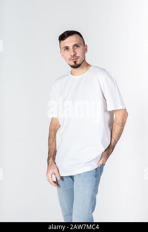 Un uomo in una t-shirt bianca su sfondo bianco, Studio ritratto Foto Stock