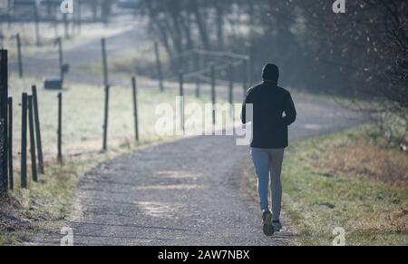 Winterbach, Germania. 07th Feb, 2020. Un uomo che fa jogging su una strada sterrata al mattino. Credito: Sebastian Gollnow/Dpa/Alamy Live News Foto Stock