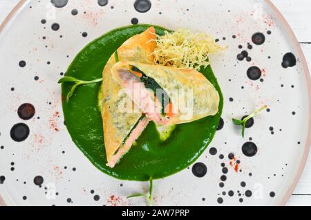 Involtini con salmone e spinaci. Lavash. Nella piastra. Vista dall'alto. Spazio libero per il testo. Stile rustico. Foto Stock