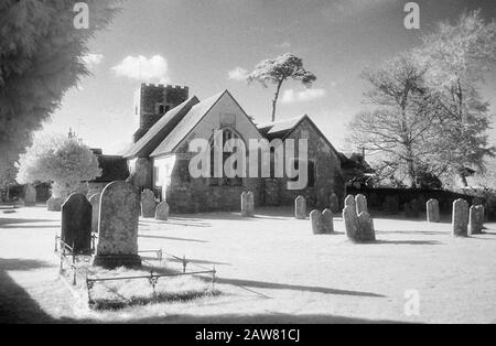 St James Without-the-Priory Gate Church e cimitero, Southwick, Hampshire, Inghilterra, Regno Unito; film a infrarossi in bianco e nero, con la sua caratteristica struttura a grana prominente, il contrasto elevato e il fogliame luminoso brillante. Foto Stock