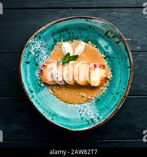 Frittelle di formaggio con farcitura al caramello, gelato e noci. Colazione. Nella piastra. Vista dall'alto. Composizione a disposizione piatta spazio di copia libero. Foto Stock
