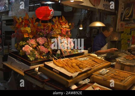 Clienti al mercato illuminato Nishiki Foto Stock