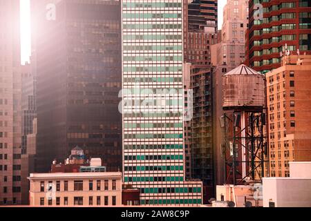 Torre dell'acqua di New York sul tetto con moderni grattacieli sullo sfondo, NY, USA Foto Stock