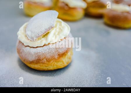 Semla svedese panna montata su sfondo grigio cemento. Shrove Martedì dessert Foto Stock