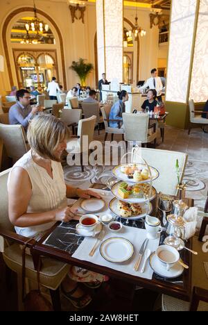 Una donna caucasica di mezza età che ha tè pomeridiano, il Peninsula hotel, Hong Kong Asia Foto Stock