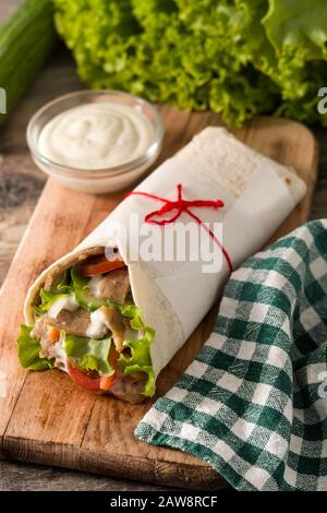 Panino doner kebab o shawarma su tavolo in legno Foto Stock