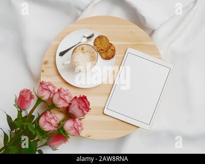 Vassoio con colazione su un letto con tablet. rendering 3d Foto Stock