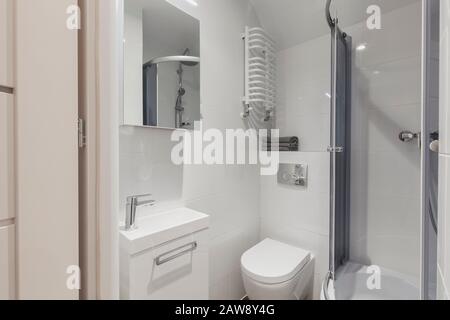 Eleganza e bagno accogliente dei vostri sogni. Interno vero, piccolo bagno con vasca, lavandino e wc ciotola Foto Stock