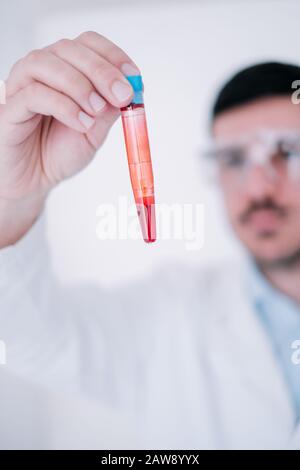 Un medico che effettua una ricerca medica in un laboratorio con provette Foto Stock