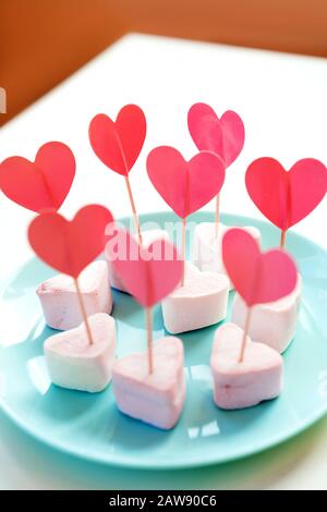 Marshmallows e cuori di carta su spiedini bloccati in meringhe Foto Stock