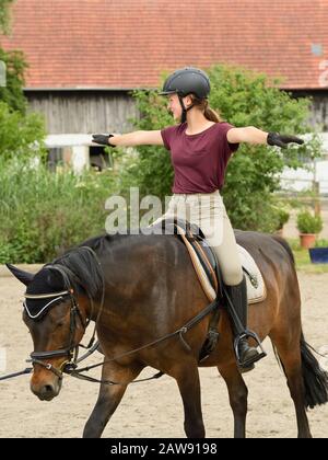 Lezione di equitazione, ragazza sul pony tedesco Foto Stock