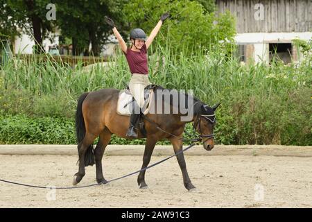 Lezione di equitazione, ragazza sul pony tedesco Foto Stock