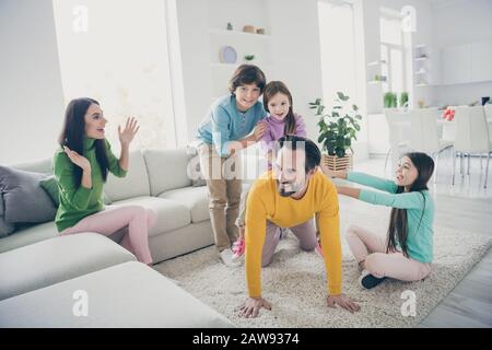 Bella allegra allegra e divertente famiglia adorabile tre bambini pre-adolescenti mamma papà divertirsi giocando a accogliente confortevole luce bianca interno Foto Stock