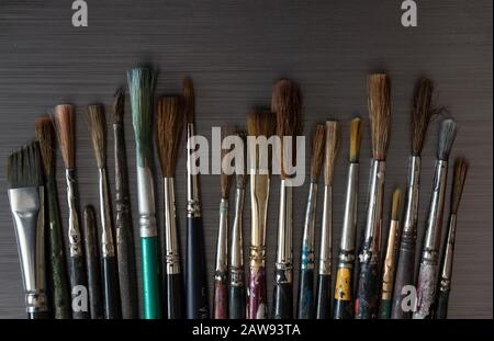 Vecchi spazzolini usati su sfondo di tessitura di metallo spazzolato Foto Stock