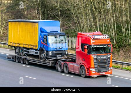 Recupero guasti HGV; autocarri pesanti per trasporto merci sfuse, trasporto Scania, camion DAF su rimorchio Scania, trasporto, camion, carico, consegna veicoli, Veicoli di recupero dell'industria dei trasporti su M61 a Manchester, Regno Unito Foto Stock