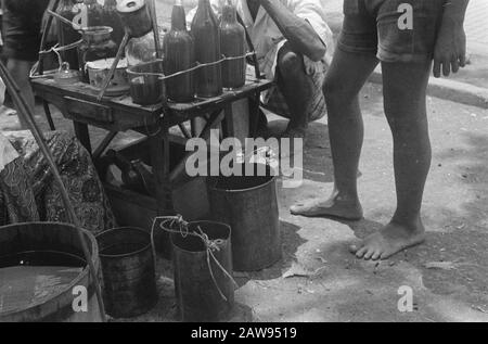 Uomo bere vetro al venditore di strada della limonata? Date: 01/01/1947 Location: Indonesia Dutch East Indies Foto Stock