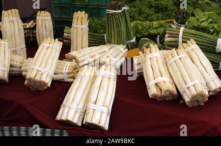 grappoli di asparagi bianchi e verdi in vendita in una stalla di mercato vegetale Foto Stock