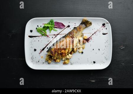 Trota alla griglia con funghi su un piatto. Vista dall'alto. Spazio libero di copia. Foto Stock