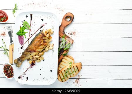 Trota alla griglia con funghi su un piatto. Vista dall'alto. Spazio libero di copia. Foto Stock