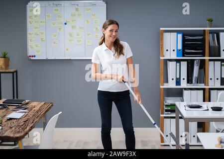 Femmina con straccio bidello di piano in un ufficio moderno Foto Stock