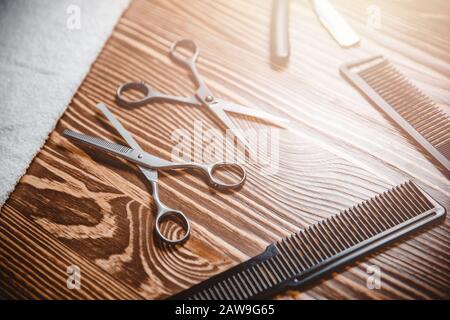 Accessori per acconciature in barbiere sfondo legno. Pettine per forbici con vista dall'alto Foto Stock