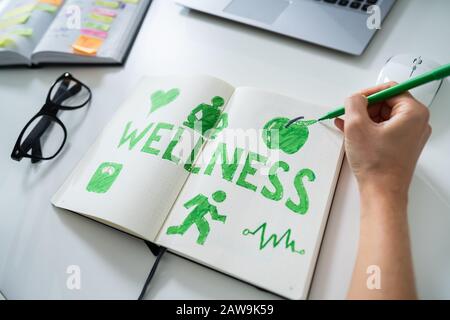 Elevato angolo di visione di un uomo del disegno a mano il concetto di benessere su Notebook Foto Stock