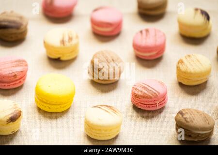 Macaroons con amaretto giallo su tovagliolo di lino. Colore orizzontale, caldo Foto Stock