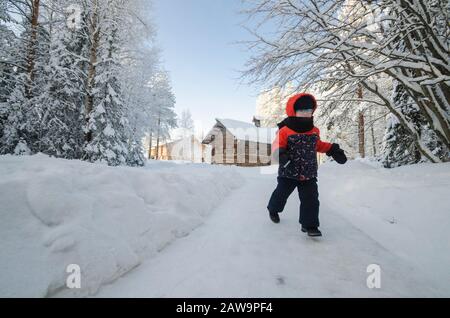 Gennaio 2020 - Malye Korely. Avvolto in un bambino di sciarpa. Camminare in ghiaccio intenso. Russia, regione di Arkhangelsk Foto Stock