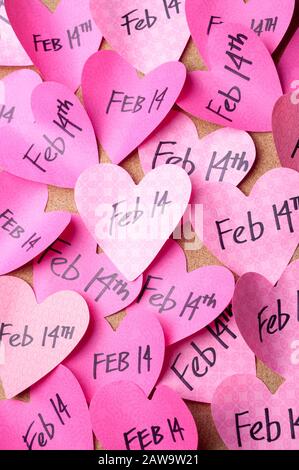 Raffica di cuori rosa appiccicosi sulla bacheca con promemoria di febbraio 14th San Valentino Foto Stock