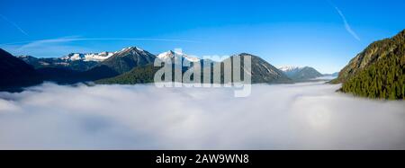 Montagne che si innalzano dalla nebbia alta sul Lago Sylvensteinsee, vicino a Lengries, Isarwinkel, vista aerea, alta Baviera, Baviera, Germania Foto Stock