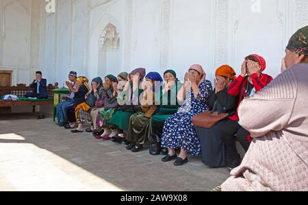 I visitatori che pregano in una nicchia tomba, la Tomba di Shah-i-Zinda, Samarcanda, la Provincia di Samarqand, Uzbekistan Foto Stock