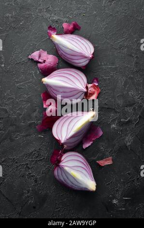 Cipolla dolce viola affettata, su sfondo di pietra nera. Vista dall'alto. Spazio libero per il testo. Stile rustico. Foto Stock