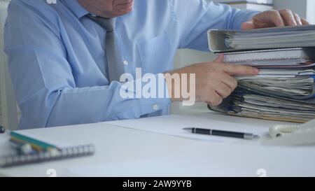 Immagine D'Uomo D'Affari Che Lavora Nell'Ufficio Di Archivio Di Contabilità Che Cerca I Documenti E I Contratti Finanziari Foto Stock