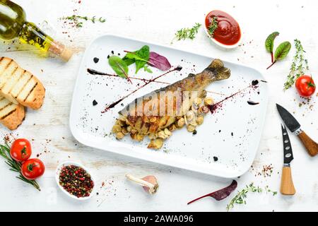 Trota alla griglia con funghi su un piatto. Vista dall'alto. Spazio libero di copia. Foto Stock
