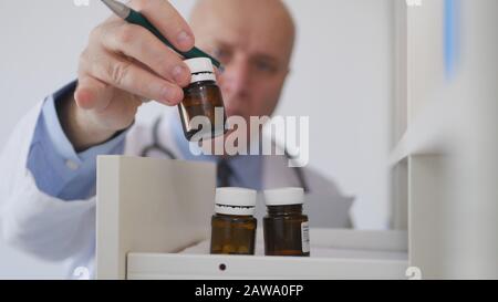 Immagine con un dottore Che Guarda in un cassetto per i medicinali Foto Stock