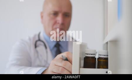 Immagine con un medico che cerca in un cassetto per i medicinali Foto Stock