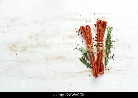 Salsiccia di vitello affumicata secca. Kabanosy. Vista dall'alto. Spazio libero per il testo. Foto Stock
