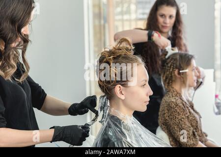 donna che ha capelli invelati mentre colorano in un salone di capelli Foto Stock