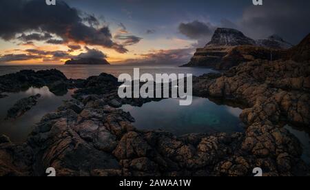 Vista dell'isola di Mykines e della montagna Arnafjall al tramonto dal porto di Gasadalur, le isole Faroe Foto Stock