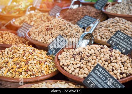 Vassoio da tavolo con una varietà di dadi in ciotole di argilla. Outlet di commercio nel mercato estivo all'aperto. Foto Stock