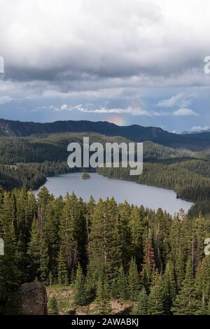 Il punto panoramico sulla Grand Mesa National Forest Colorado vanta oltre 300 laghi. Parziale Rainbow sopra Island Lake, che è una delle destinazioni più popolari Foto Stock