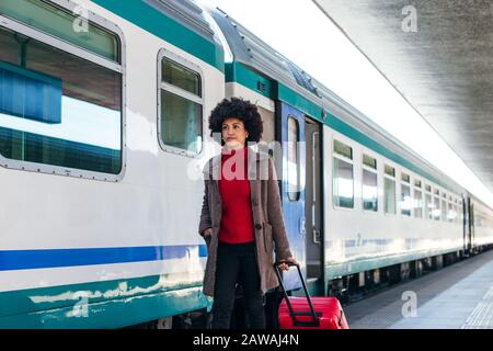 Donna elegante che va per un viaggio d'affari in treno Foto Stock