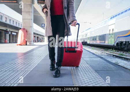 Primo piano di una donna che cammina e trascina valigia borsa Foto Stock