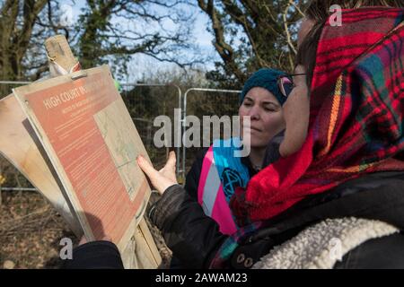 Harefield, Regno Unito. 7 Febbraio 2020. Sarah Green e gli attivisti ambientali di Extinction Rebellion vedono una vecchia versione di un'ingiunzione di High Court che si trova sulla strada dove gli ingegneri HS2 hanno recintato in compagni attivisti che hanno scalato un albero di quercia veterano per cercare di proteggerlo dalla gelificazione. Credit: Mark Kerrison/Alamy Live News Foto Stock