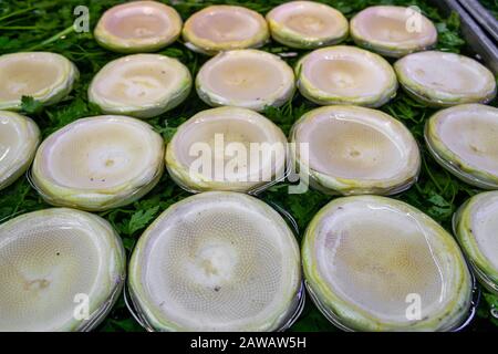 Pelati e puliti carciofi crudi nell'acqua sul prezzemolo Foto Stock
